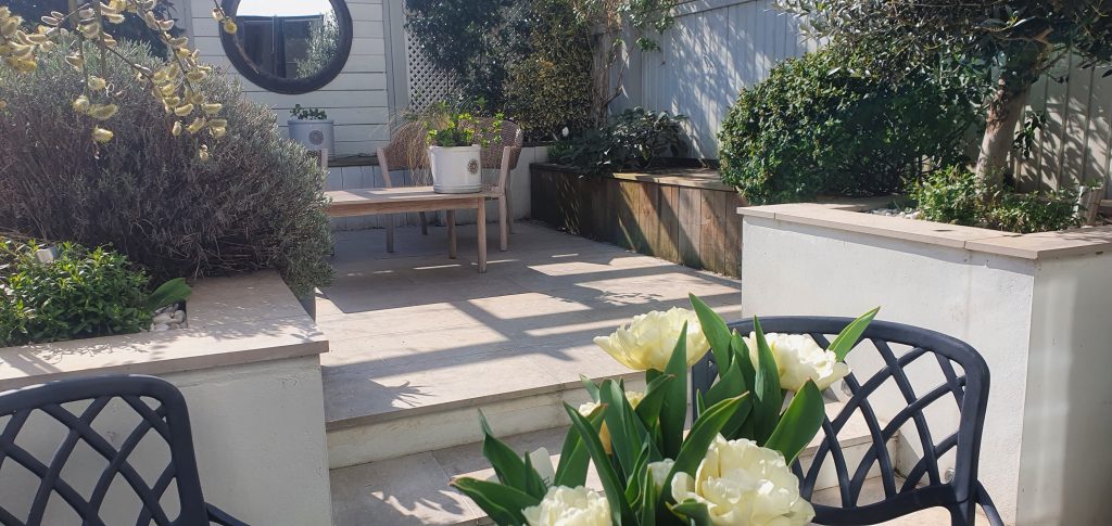 Garden steps between raised planters and an outdoor seating area