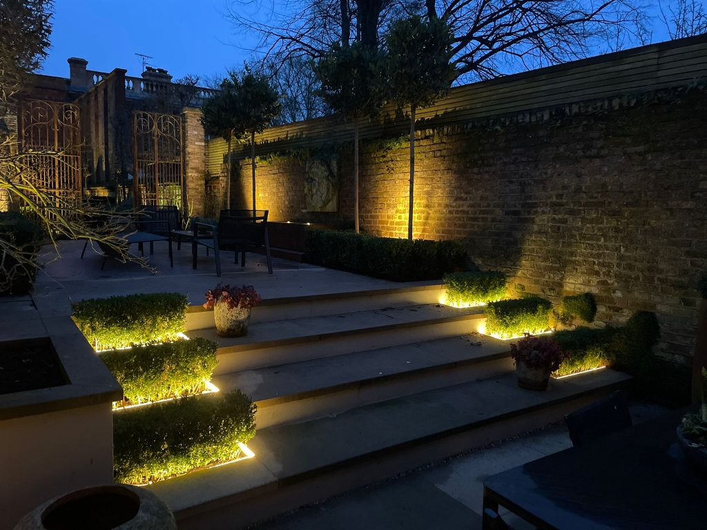 Illuminated steps, planting and brick wall